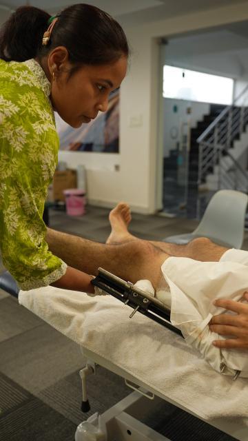 Supportive care team assisting in postoperative physiotherapy